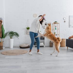 Cheerful,Young,Woman,Playing,With,Akita,Inu,Dog,Near,Bearded