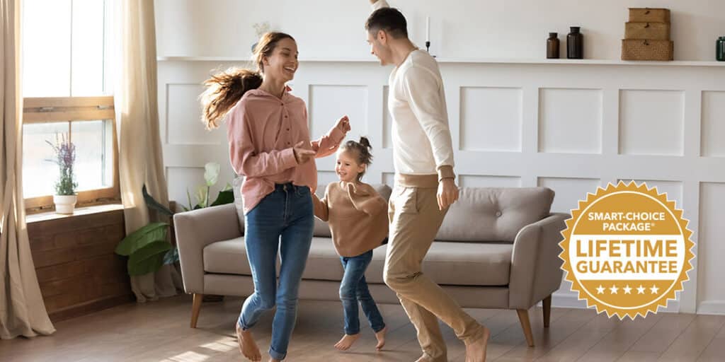 Cheery,Couple,Dancing,With,Little,Daughter,Barefoot,On,Wooden,Laminate