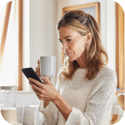 Lady on her phone with a mug of coffee